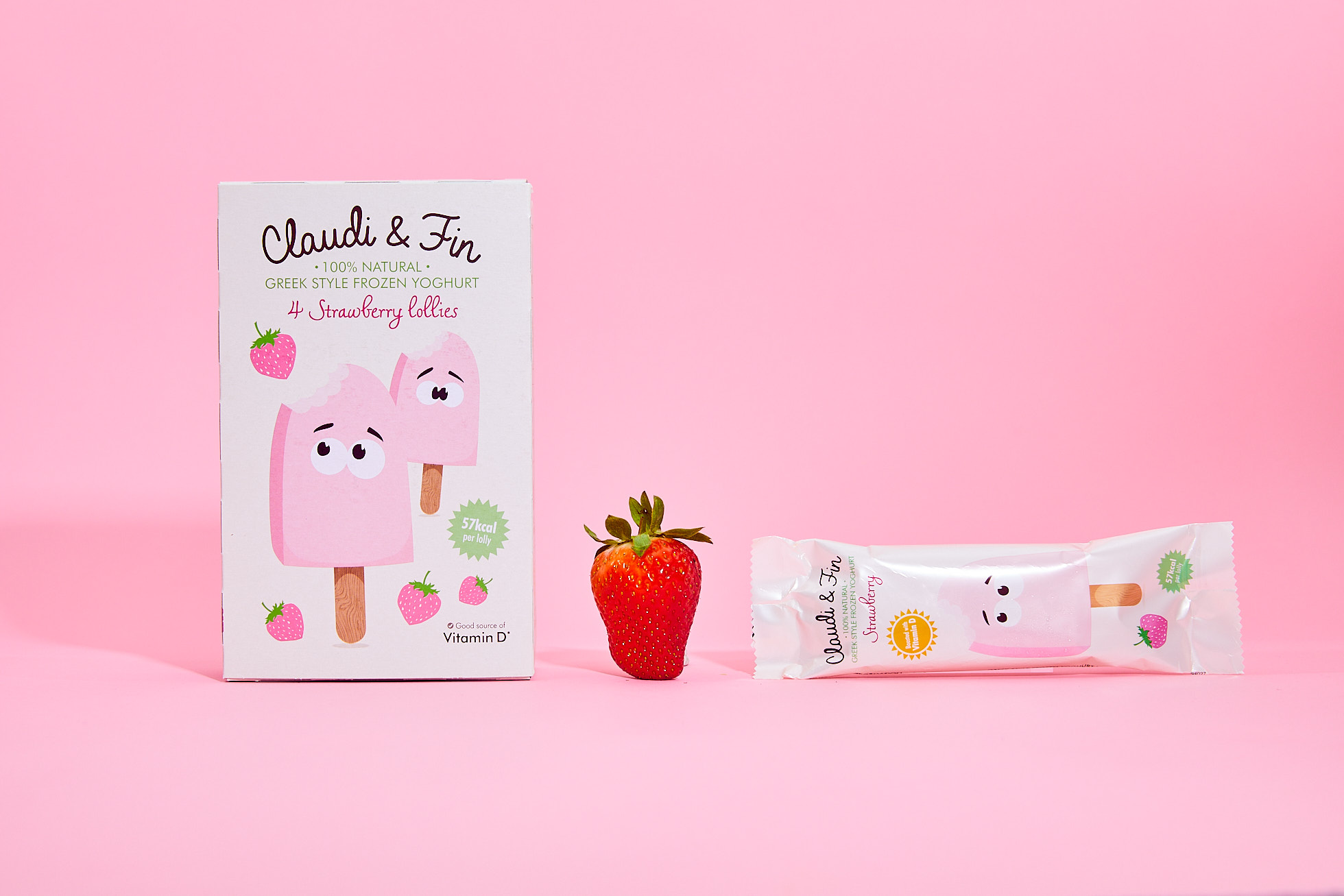 Box of Claudi and Fin ice lollies with a lolly and strawberry against a pink background
