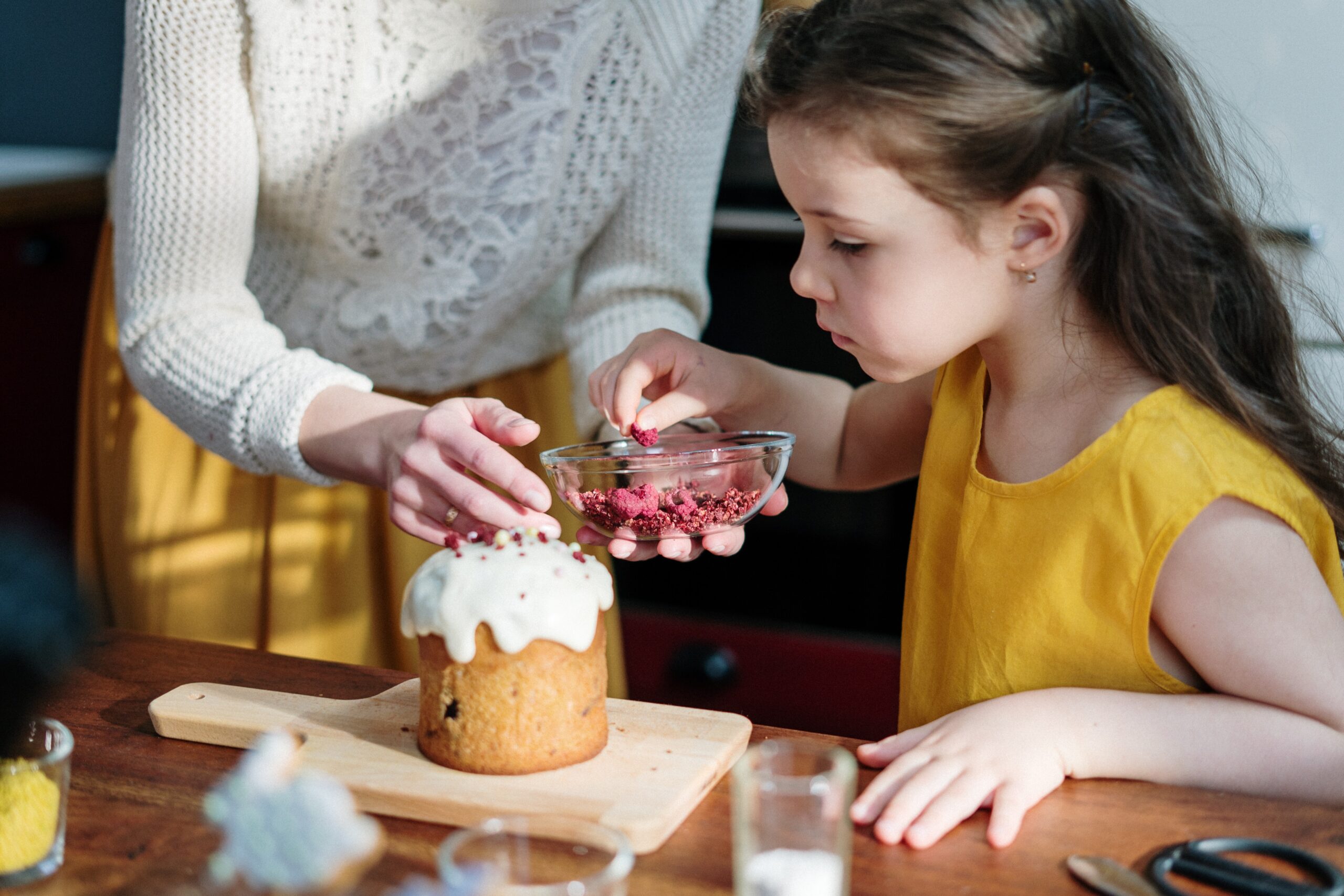 child decorating a cake