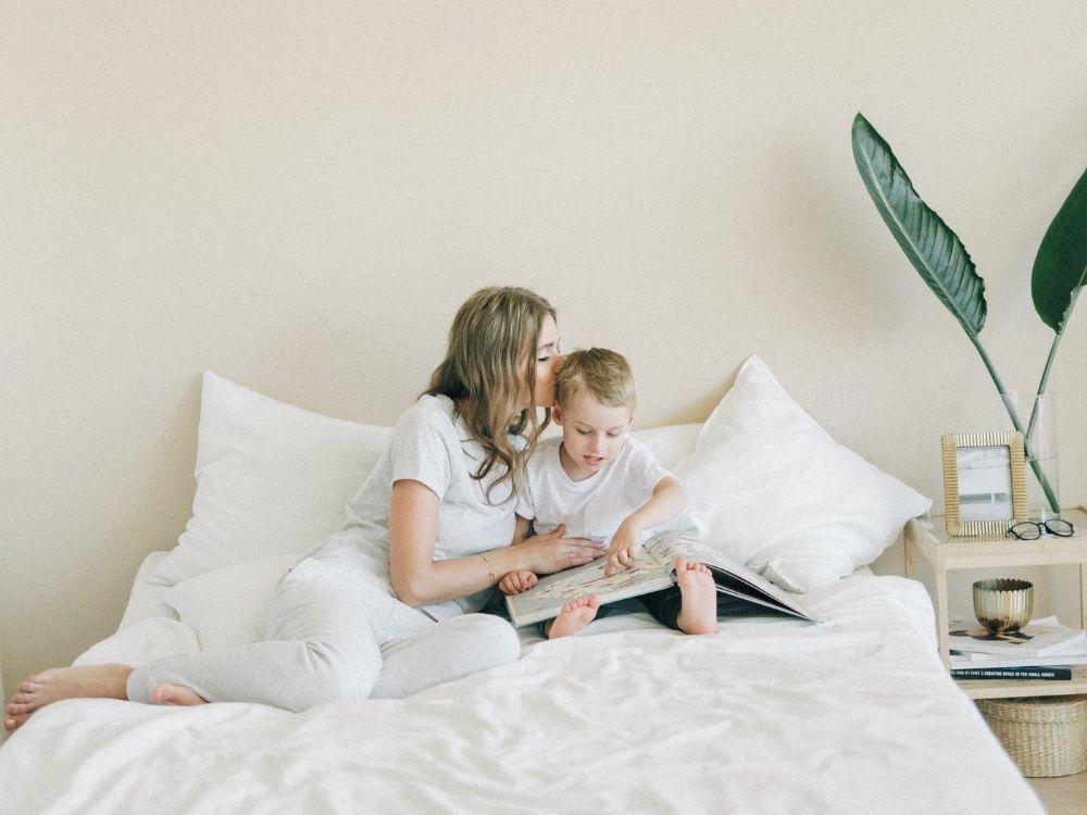Parent and son reading on a bed