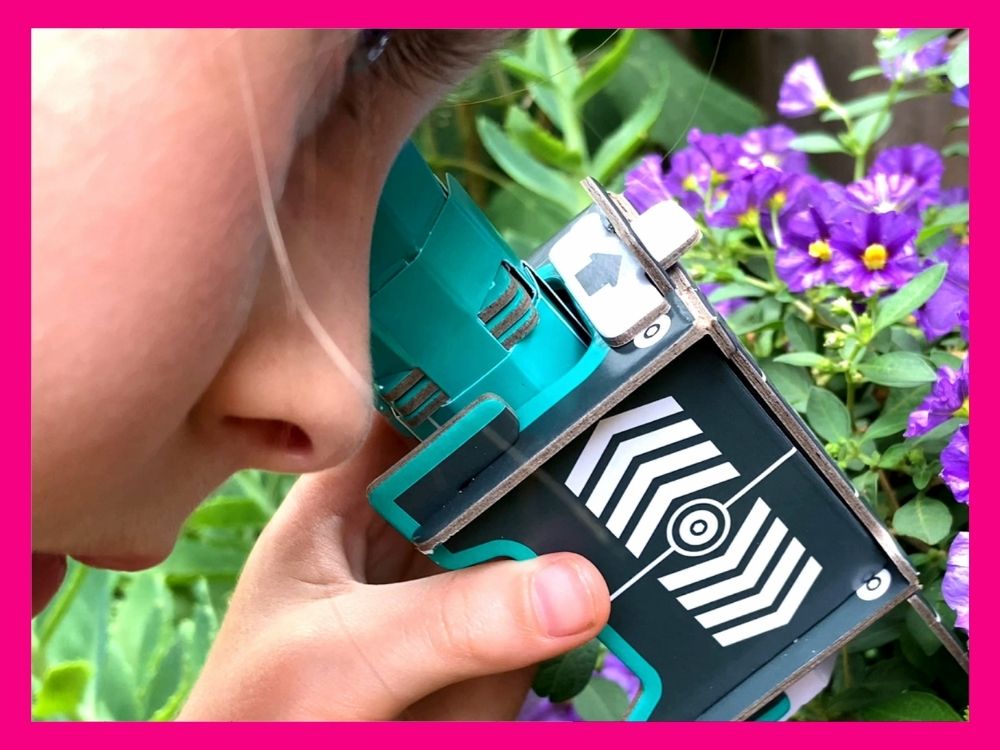 Child looking at flowers through a cardboard microscope